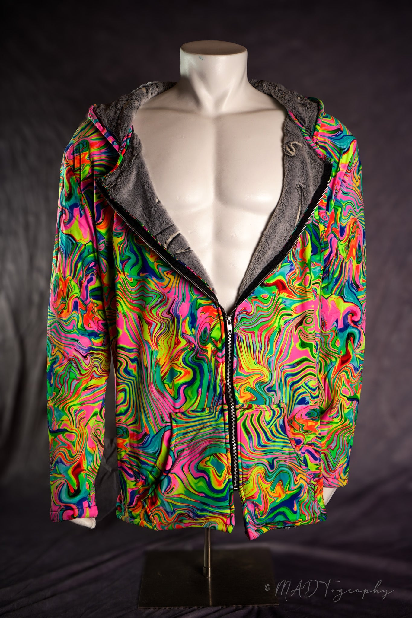 Colorful fluorescent rainbow jacket with a wavy pattern on a mannequin against a dark background
