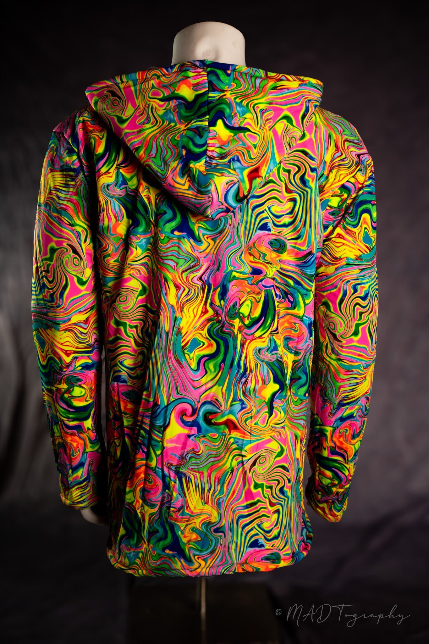 Colorful fluorescent rainbow jacket with a wavy pattern on a mannequin against a dark background