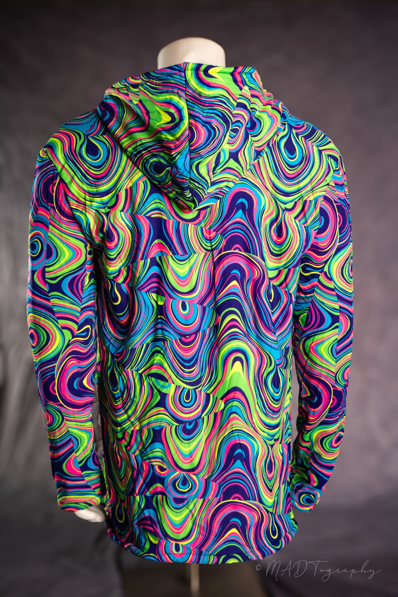 Colorful psychedelic patterned jacket on a mannequin against a dark background