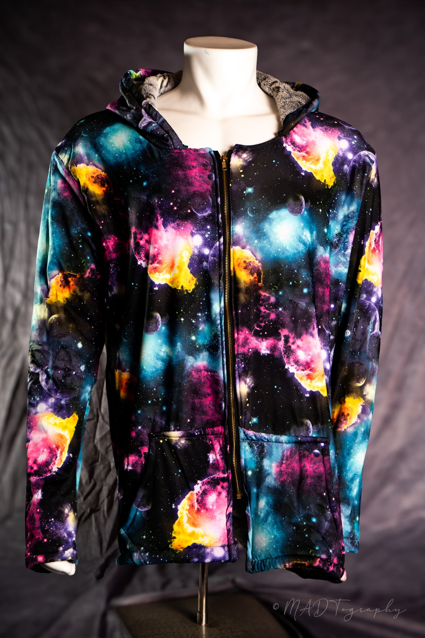 Colorful galaxy-themed jacket on a mannequin against a dark background