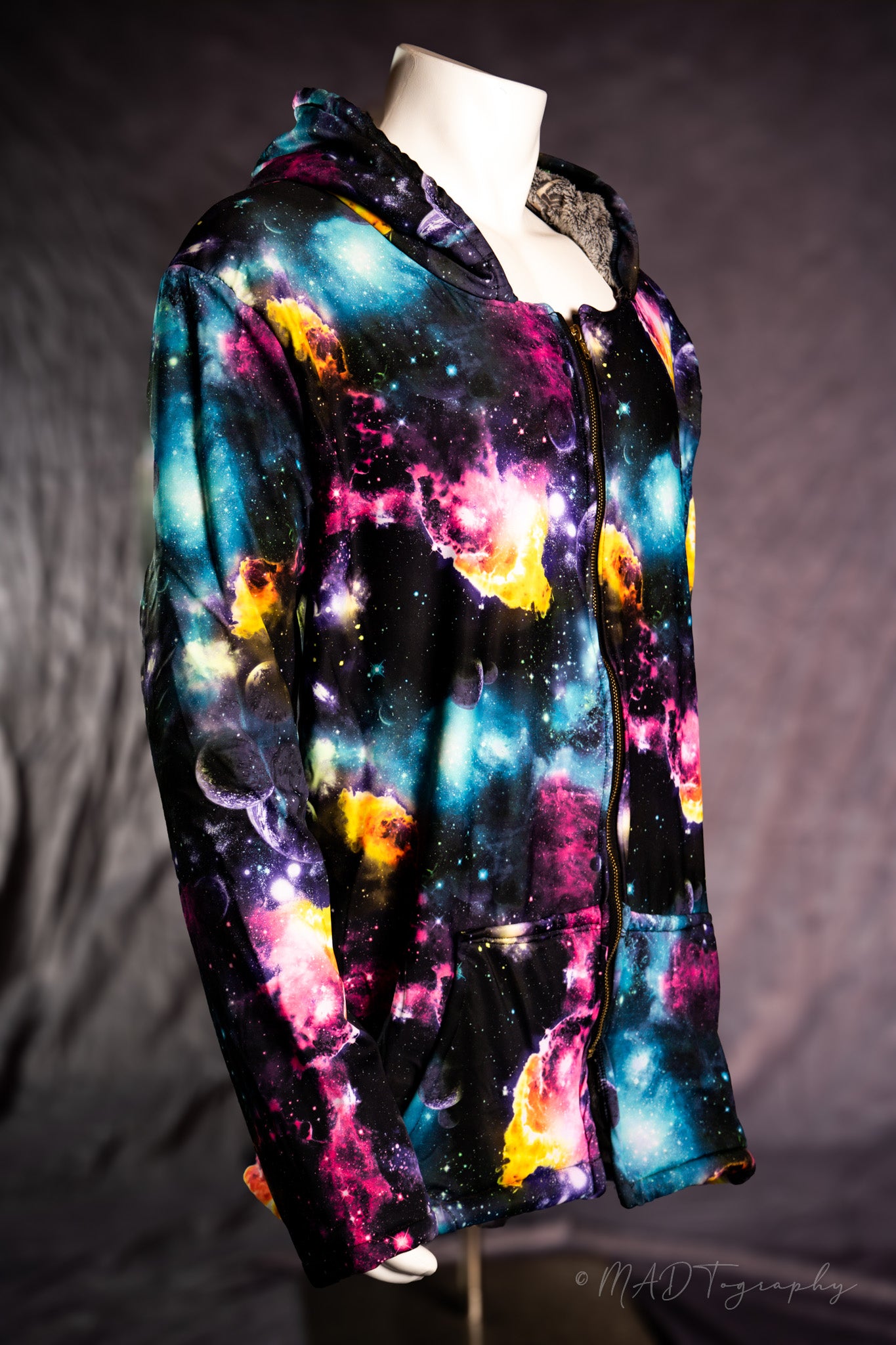 Colorful galaxy-themed hoodie on a mannequin against a dark background