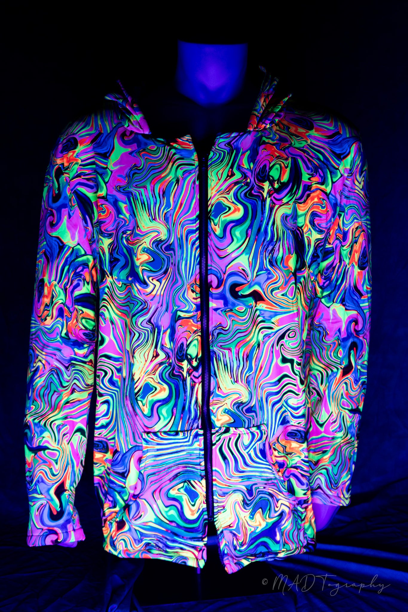 Colorful fluorescent rainbow jacket with a wavy pattern on a mannequin against a dark background