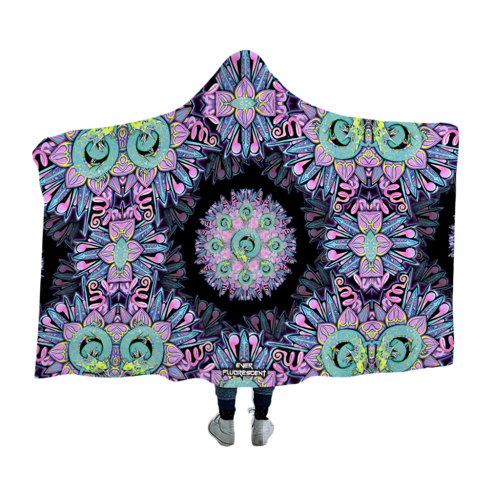 Person wearing a colorful mandala-patterned hooded blanket on a white background